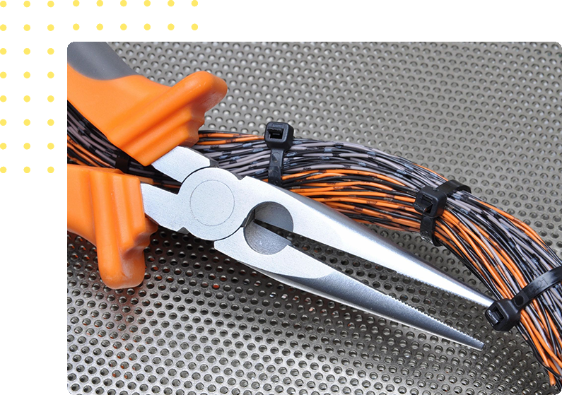 A pair of scissors with orange handles and wires.